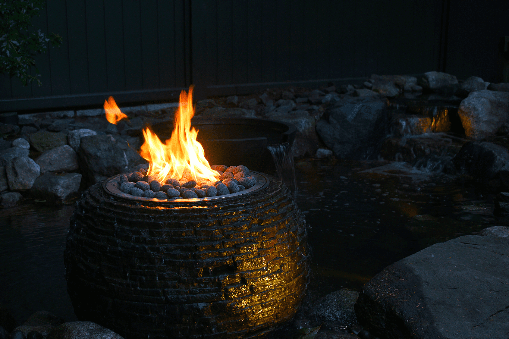 Outdoor fire pit with glowing flames at night.
