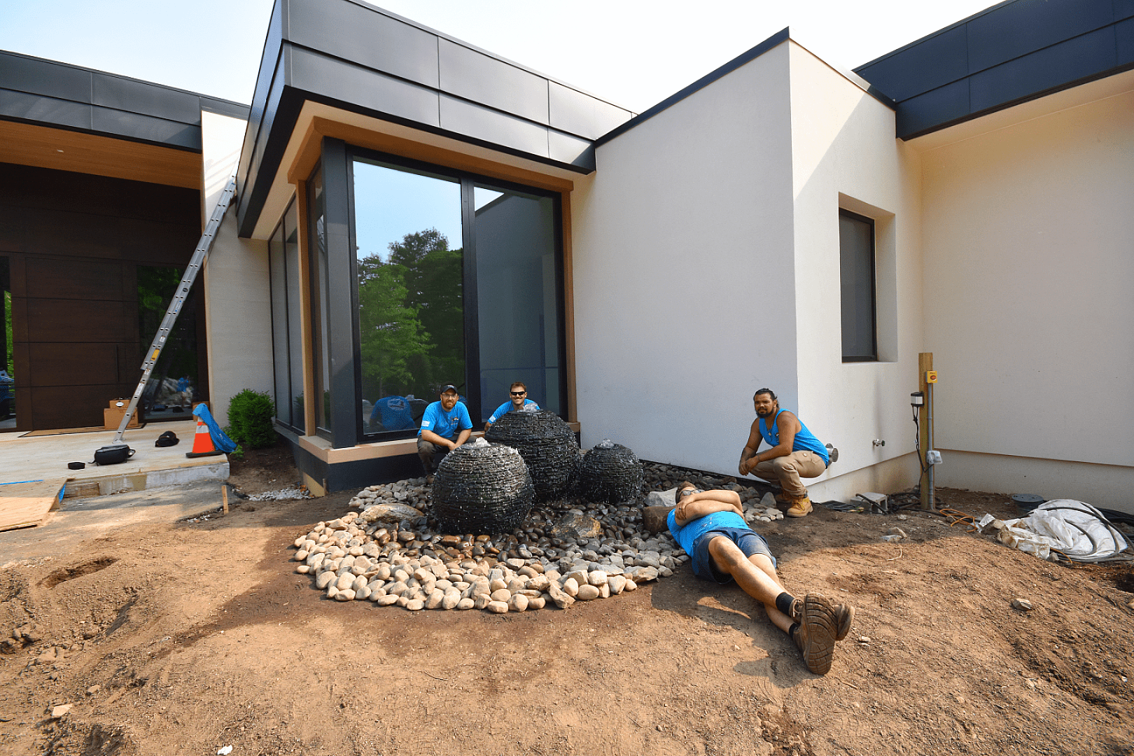 Construction workers landscaping modern house exterior