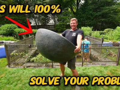 Man lifting large stone in garden